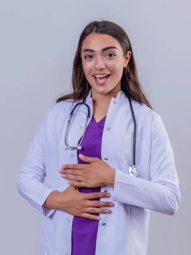 young-woman-doctor-white-coat-with-phonendoscope-smiling-with-happy-face-with-hands-stomach-white-isolated-background